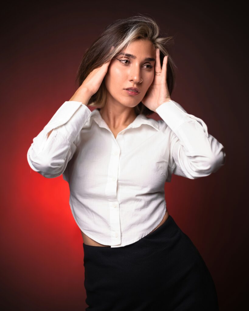 Confident woman in a white shirt against a red studio backdrop
